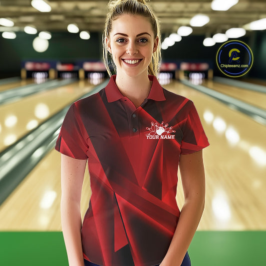 Woman wearing a red and black polo shirt with a logo and text in a bowling alley.
