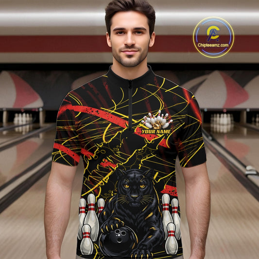 A man wearing a black bowling-themed graphic shirt with a black panther, bowling pins, and yellow/red abstract lines, set against a bowling alley background.