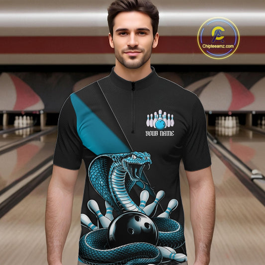 Male model wearing a black quarter-zip in a bowling lane with blue cobra artwork and bowling graphics.