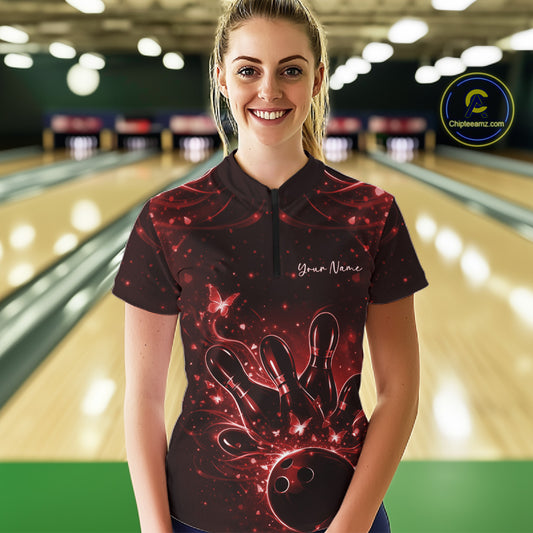 Female model wearing a black and red bowling quarter-zip shirt in a bowling venue with glowing butterfly and bowling-themed graphics.