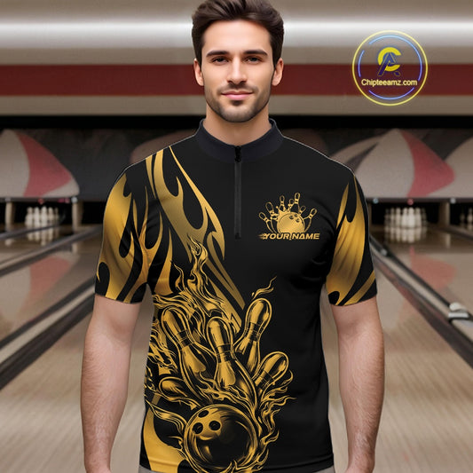 Male model front view in bowling venue wearing black quarter zip shirt with golden metal tribal flame bowling ball striking pins in powerful sports design.