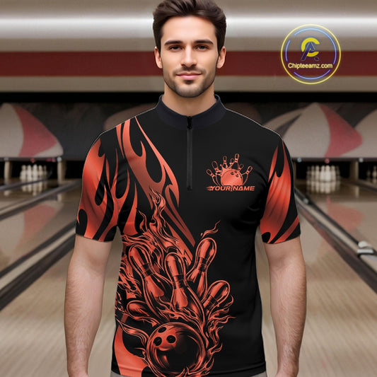 Male model front view in a bowling lane wearing a black quarter zip shirt with red gradient tribal flames and a bowling ball striking pins in action.
