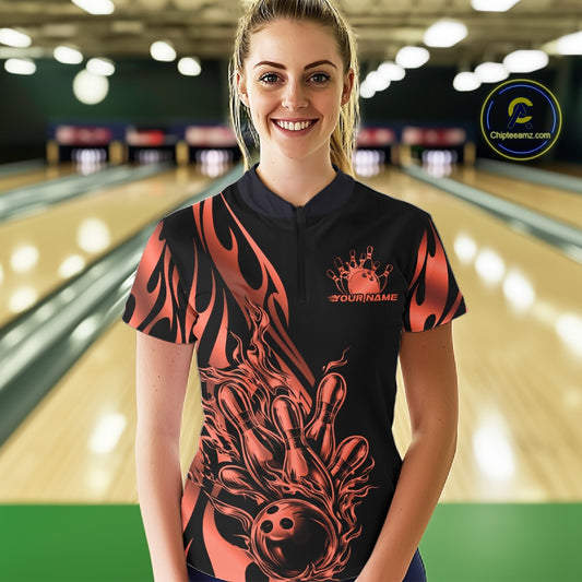 Female model front view in bowling alley wearing black quarter zip shirt with red gradient tribal flame bowling ball striking pins dynamic artwork
