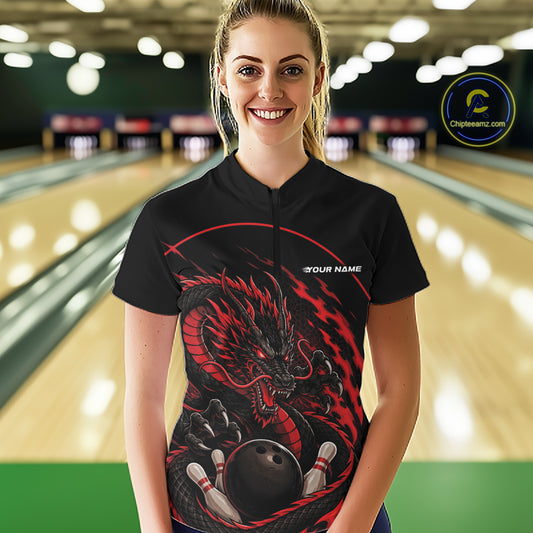Front view of a happy female model in a bowling alley wearing a red custom quarter-zip bowling shirt featuring an aggressive dragon with flames in a dynamic and energetic design.