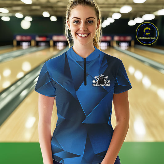 Woman wearing a blue bowling shirt with a personalized design in a bowling alley.