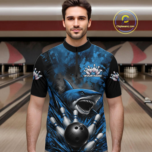 Man wearing a blue and black bowling shirt with shark design in a bowling alley.