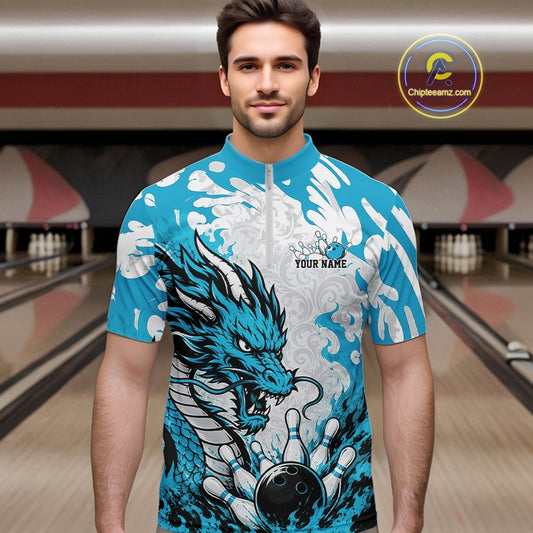 Man wearing a blue and white dragon-themed bowling shirt in a bowling alley.