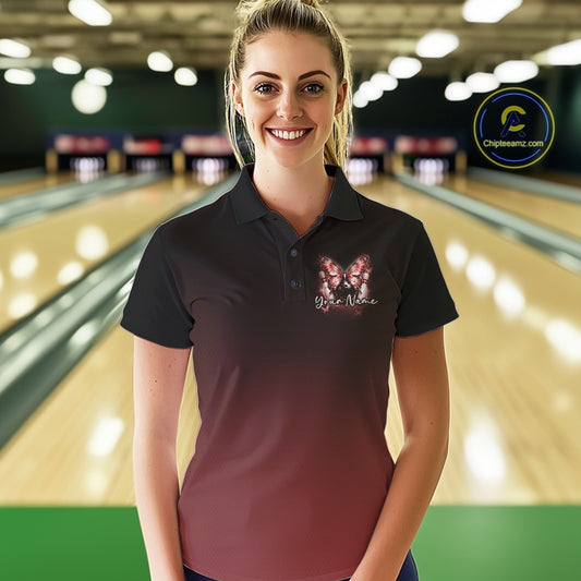 Female model at a bowling lane wearing a red bowling polo shirt with glowing butterflies, a bowling ball centerpiece, and cosmic-themed artwork.