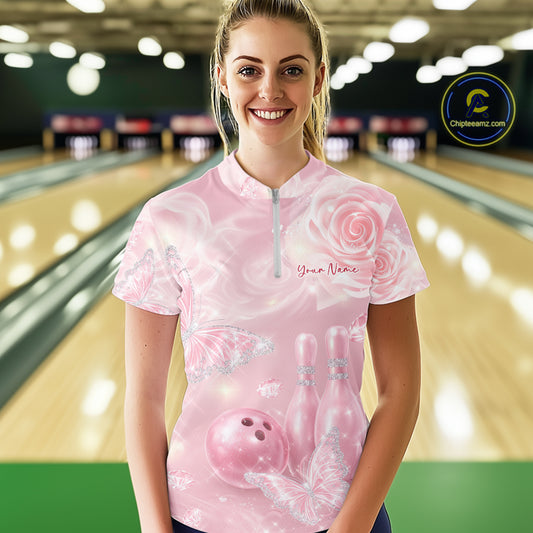 Front view of a female model at the bowling lane wearing a quarter-zip bowling shirt featuring glitter butterflies, roses, bowling pins, and a bowling ball.