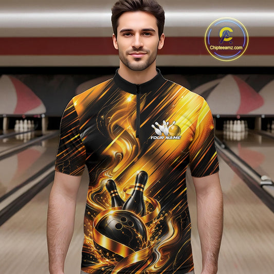 Male model wearing a bowling quarter zip shirt featuring a black and gold bowling ball striking pins with flowing metallic ribbon accents, shown from the front in a bowling lane.