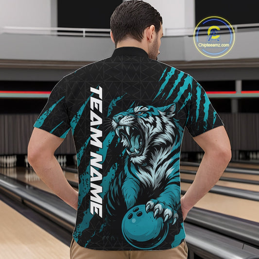 Male model wearing a black and teal blue bowling quarter-zip shirt in a bowling lane featuring a roaring tiger holding a teal blue bowling ball with teal blue claw-stripe artwork and a geometric background pattern.