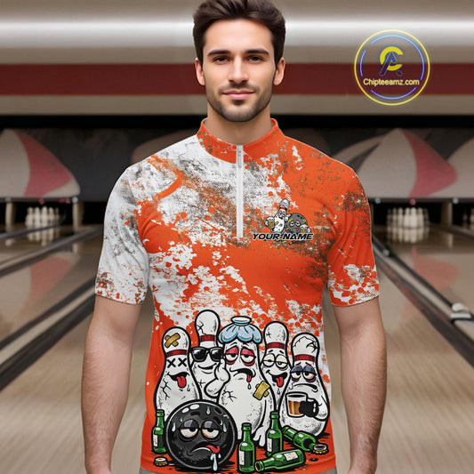 Male model in a bowling lane wearing orange and white quarter zip shirt, front view featuring grunge splatter pattern with cartoon bowling-themed artwork