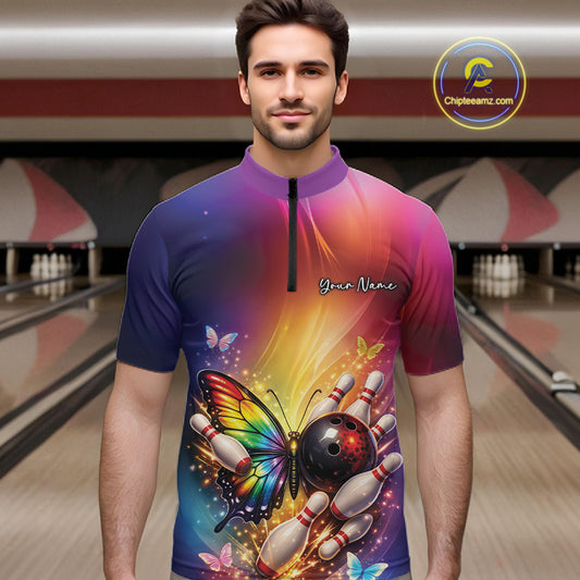 Male model wearing a bowling quarter-zip shirt at a bowling lane with a rainbow butterfly, bowling ball, and scattered pin artwork.