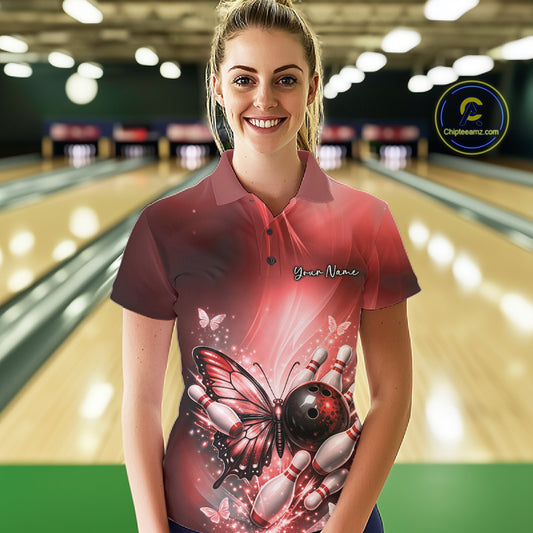 Female model at a bowling lane wearing a red bowling polo shirt with butterfly artwork, a bowling ball, and scattered pin graphics.