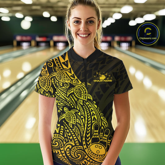 Female model wearing a black and gold bowling quarter-zip shirt at the bowling lane with turtle Polynesian bowling graphics.