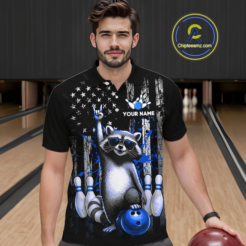 Man wearing a black shirt with a raccoon graphic in a bowling alley, holding a bowling ball.