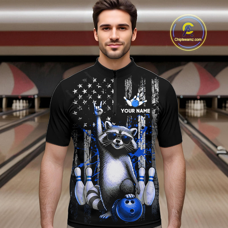 Man wearing a black shirt with a raccoon graphic in a bowling alley.