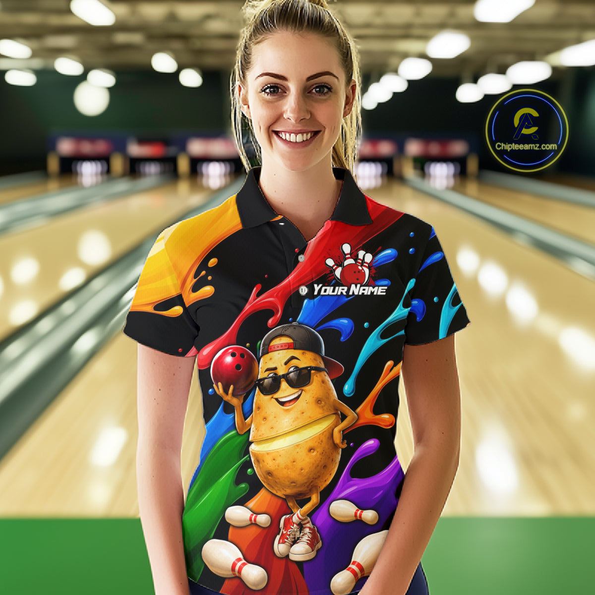 Person wearing a colorful bowling shirt with a cartoon potato design in a bowling alley.