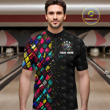 Load image into Gallery viewer, Man wearing a colorful and black bowling shirt with a logo and text in a bowling alley.