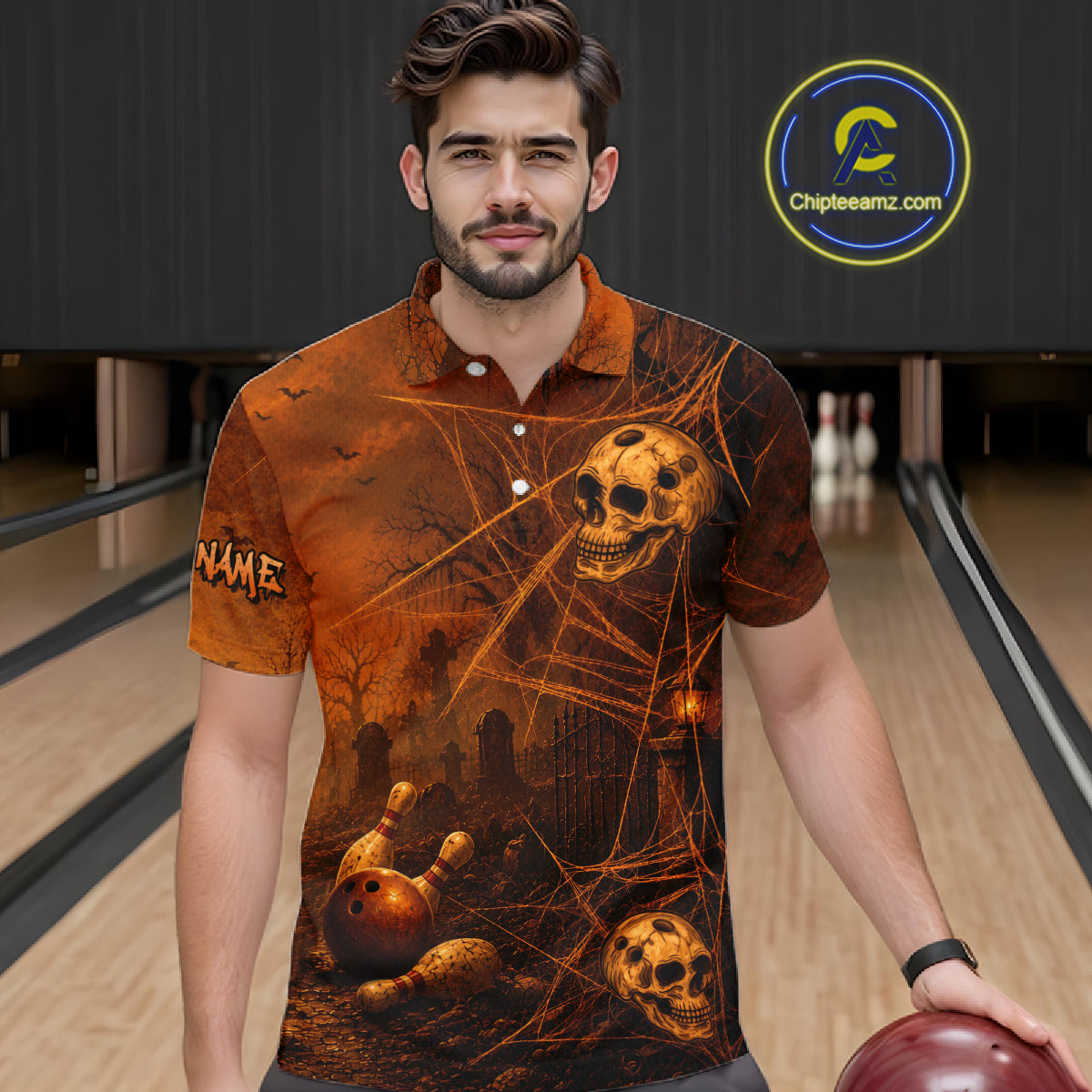 A man wearing a short-sleeve polo shirt with a spooky Halloween graphic print featuring skulls, bowling pins, and cobwebs in orange and black tones, standing in a bowling alley. 