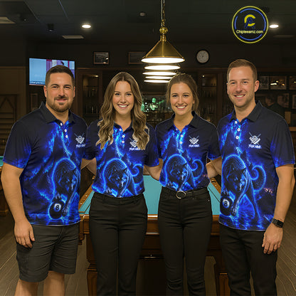 Four people standing together in a dimly lit indoor venue, wearing matching dark blue polo shirts with a glowing blue cosmic or nebula-style graphic print and black pants. A pool table is visible behind them