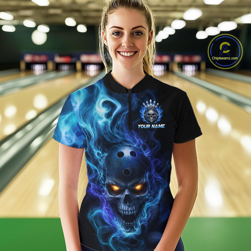 Woman wearing a black bowling quarter zip shirt featuring a flaming skull with glowing orange eyes, blue smoke effects, and custom “YOUR NAME” text.