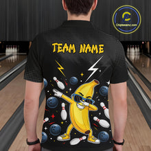 Load image into Gallery viewer, Man wearing a black polo with a colorful design of a banana character and bowling elements, standing in a bowling alley.