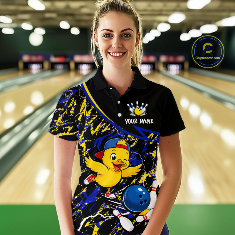 Person wearing a colorful bowling shirt with a cartoon character in a bowling alley.