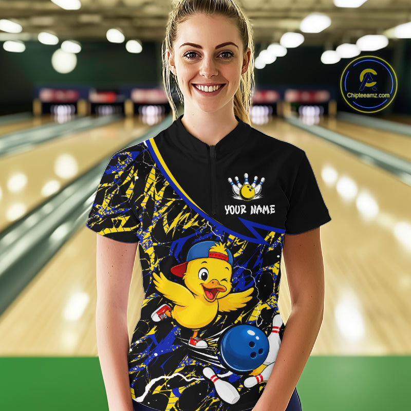 Person wearing a bowling shirt with a cartoon duck design in a bowling alley.