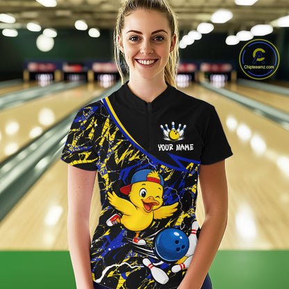 Person wearing a bowling shirt with a cartoon duck design in a bowling alley.