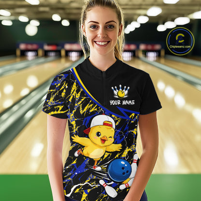 Person wearing a bowling shirt with a cartoon chicken design in a bowling alley.