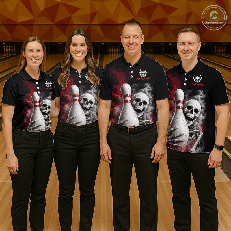 Four people standing together in a bowling alley wearing matching black short-sleeve polo shirts with a large graphic print of a skull and bowling pins, paired with black pants. A circular logo for Bowling.