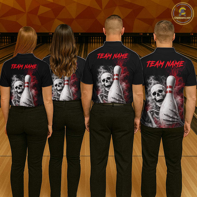 Four people standing with their backs to the camera in a bowling alley, wearing matching black short-sleeve shirts with a large back graphic of a skeleton hand holding bowling pins, skulls, and red 'TEAM NAME' text.