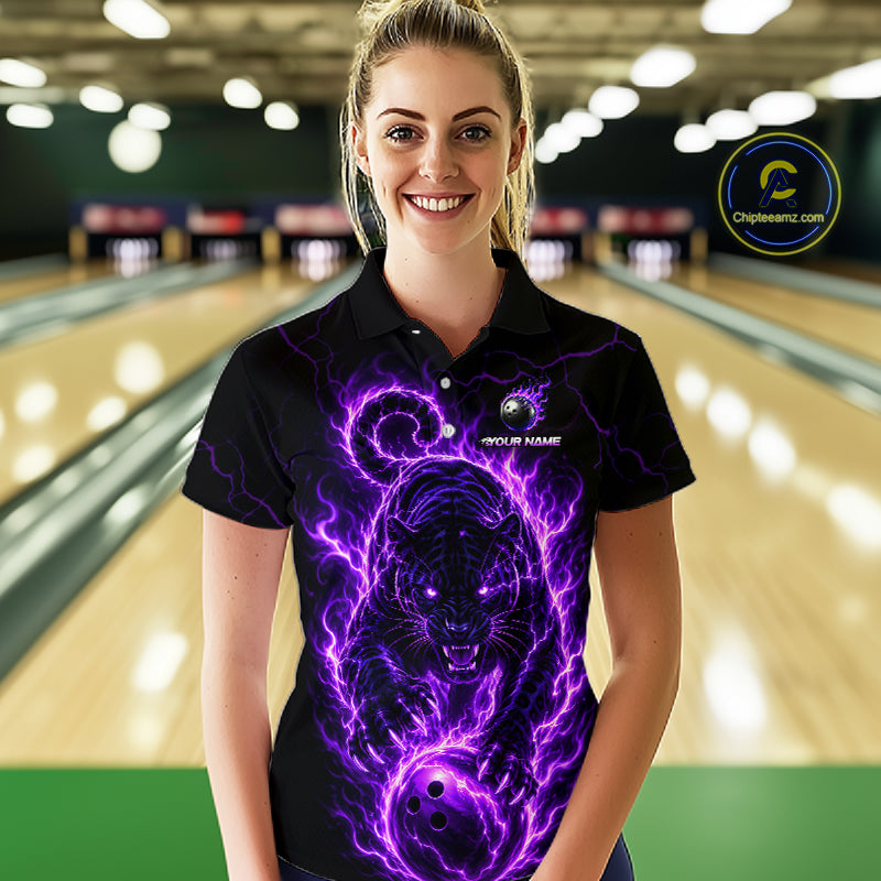 Woman wearing a black polo shirt with a purple panther design in a bowling alley.