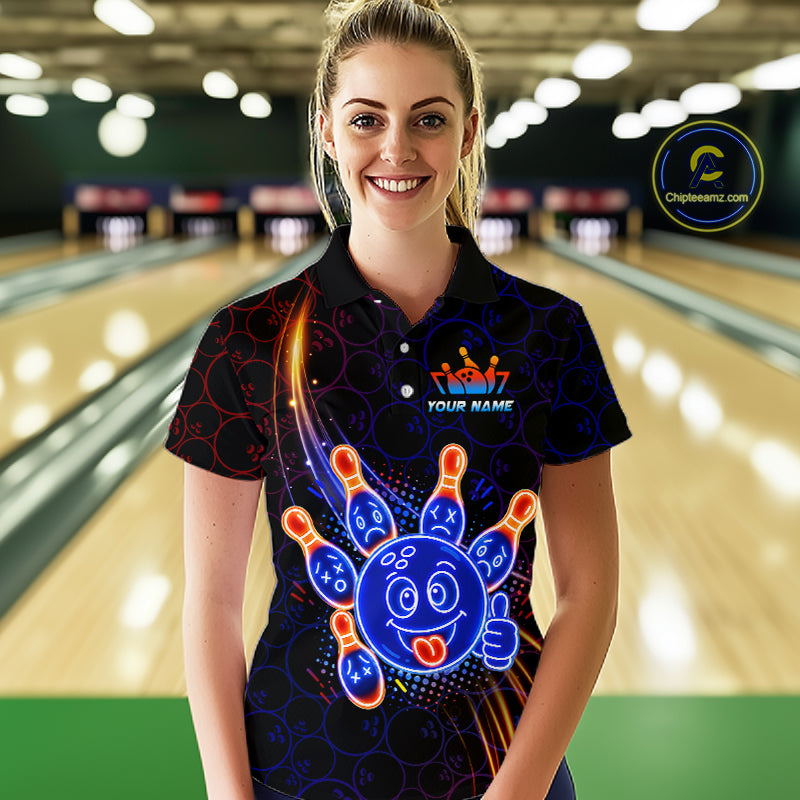 Woman wearing of a black bowling polo shirt with neon blue and orange cartoon bowling ball and pin graphics, plus custom player name text.