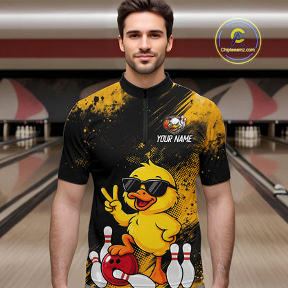 A man wearing a custom bowling-themed short-sleeve polo shirt with a yellow duck graphic, black and yellow splatter design, and 'YOUR NAME' placeholder text on the chest. The background shows blurred bowling alley lanes.