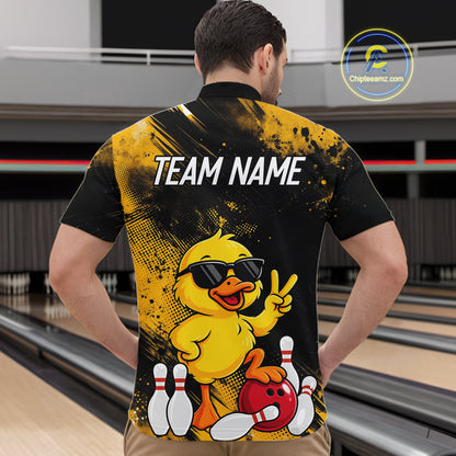 A man viewed from behind wearing a black and yellow bowling-themed short-sleeve shirt with a cartoon duck graphic and the text 'TEAM NAME' on the back. Bowling lanes are visible in the background, and a 'Chilebeansz.
