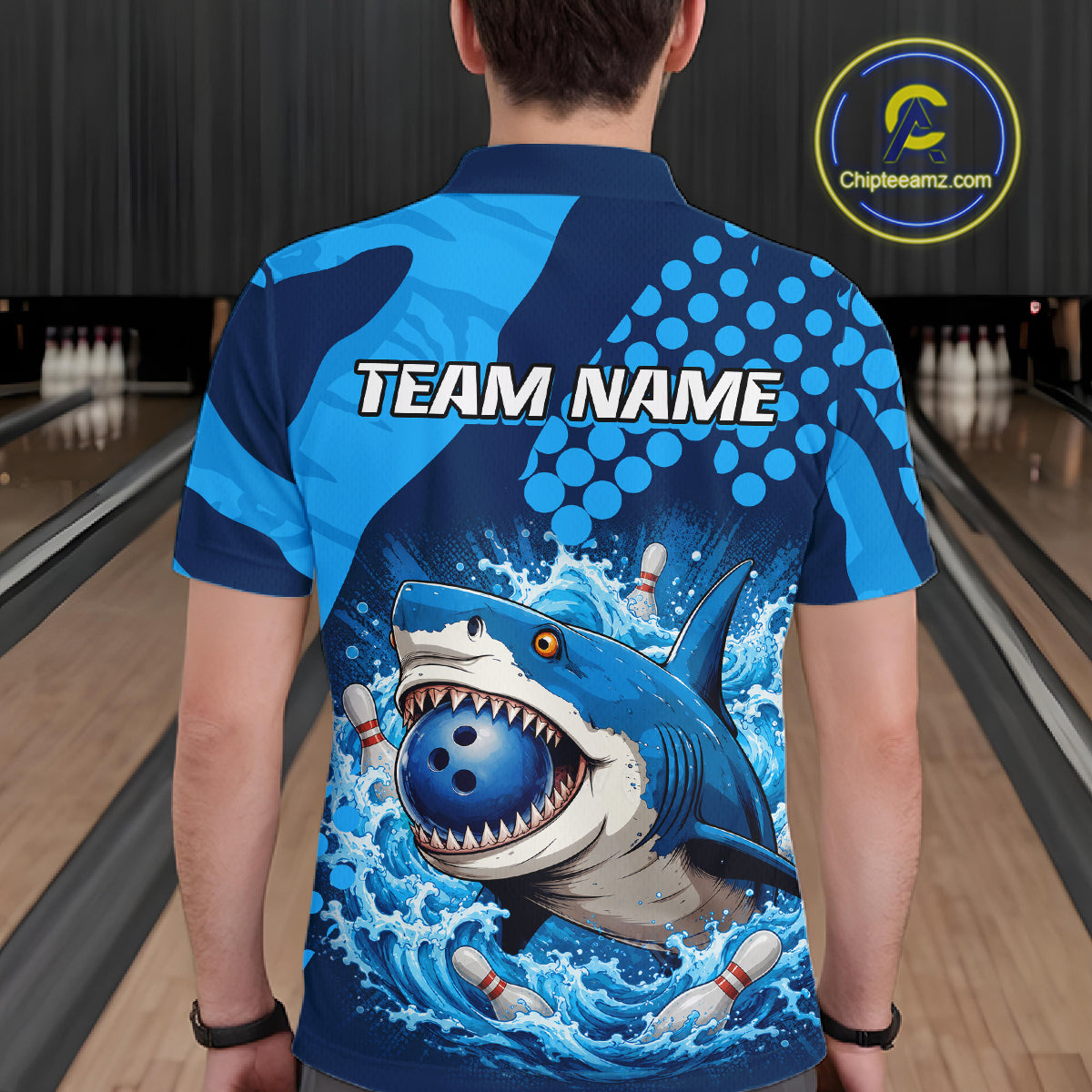 Person wearing a blue and gray shark-themed bowling shirt with 'TEAM NAME' text on a bowling alley background.