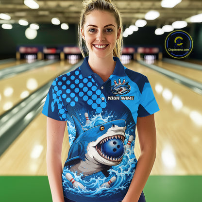 Person wearing a blue bowling shirt with a shark design in a bowling alley.