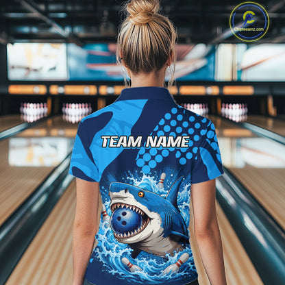 Person wearing a blue and black bowling shirt with a shark design in a bowling alley.