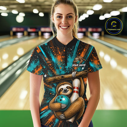 A woman standing in a bowling alley wearing a custom bowling shirt with a sloth and bowling ball graphic, teal and orange paint splatter design, and a black collar. 