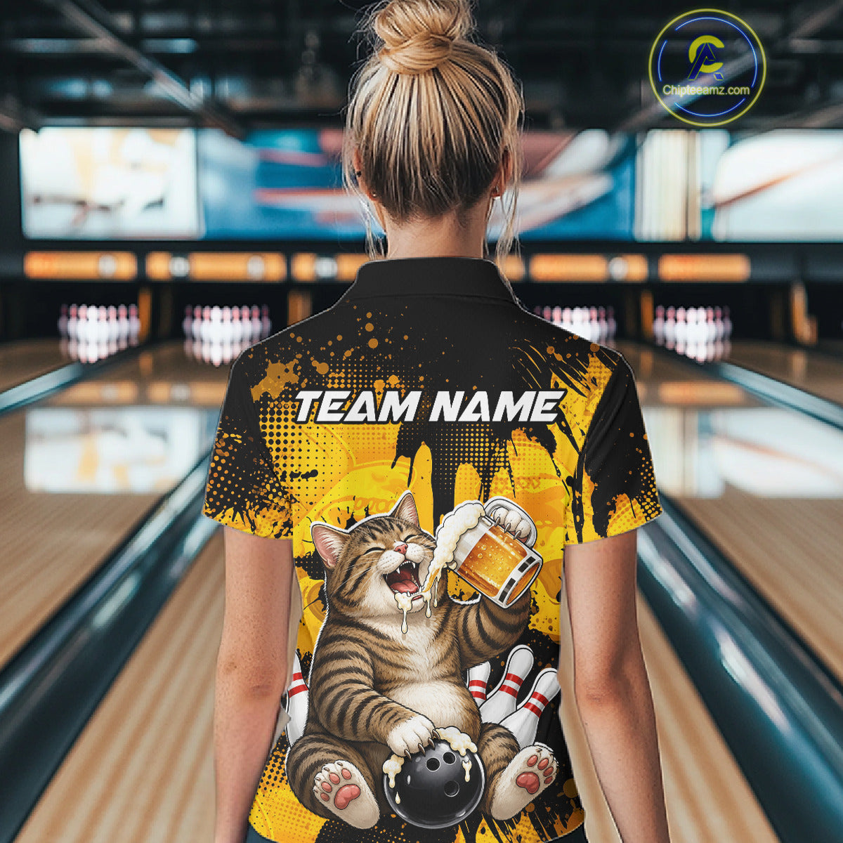 Person wearing a shirt with a cat graphic and 'Team Name' text in a bowling alley.