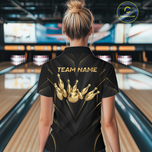 Load image into Gallery viewer, Woman wearing a black bowling shirt with gold designs and 'TEAM NAME' text in a bowling alley.