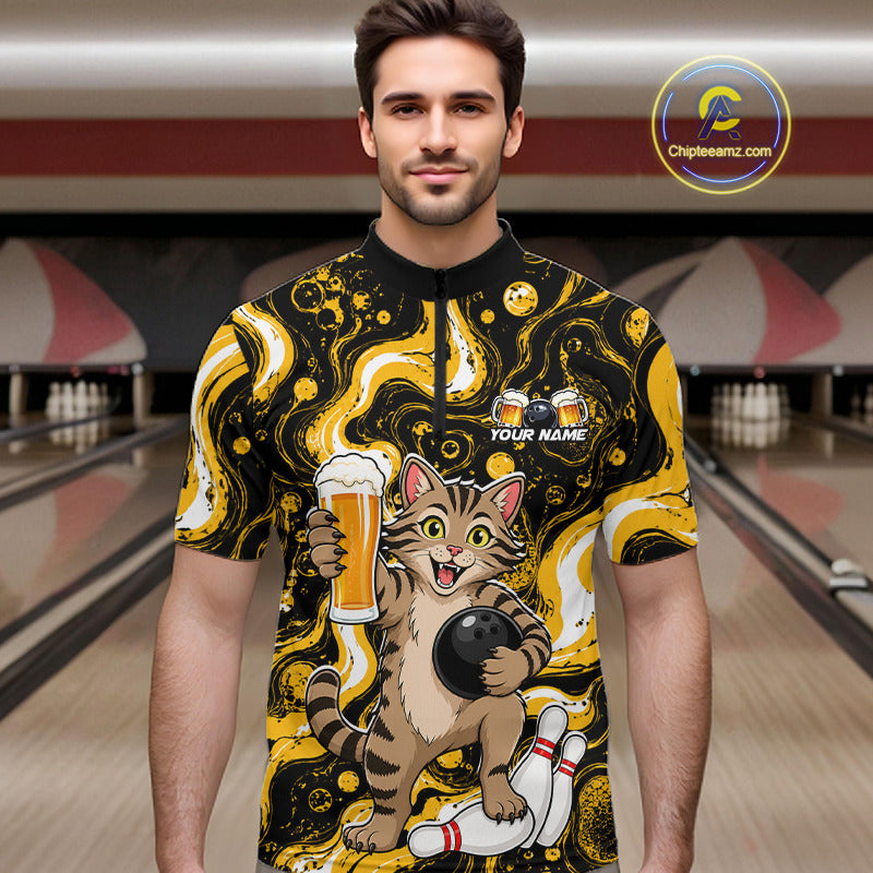 A man wearing a short-sleeve bowling-themed graphic shirt with a cartoon cat holding a beer glass and bowling ball, set against a blurred bowling alley background. 