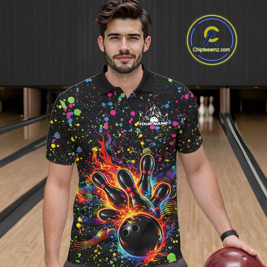 Male model wearing a black bowling polo shirt at the lane with vibrant splatter accents and bowling strike artwork.