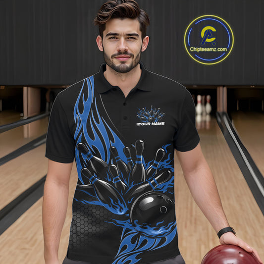 Male model seen from the front in a bowling lane wearing a black polo shirt featuring a blue flaming black bowling ball striking pins in a dynamic sports scene.