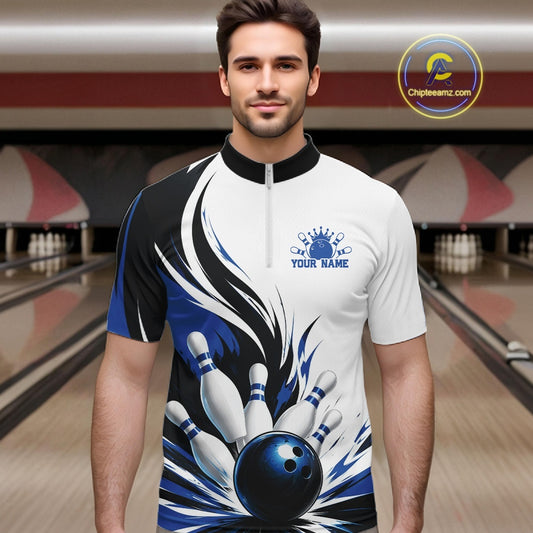 Male model wearing a white, black, and blue bowling quarter zip shirt with a flaming bowling ball knocking down pins graphic, shown from the front at a bowling lane.