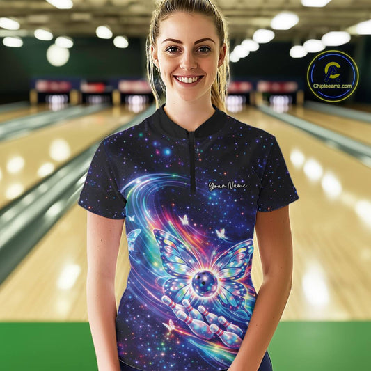 Female model wearing a colorful quarter-zip bowling shirt in a bowling alley featuring glowing butterfly wings and a bowling ball centerpiece.