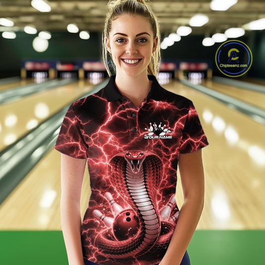 Female model at the bowling lane wearing a bowling polo with red cobra and bowling ball graphics against lightning.