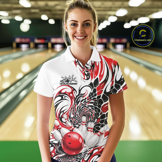 Female model at the bowling lane wearing a white bowling polo shirt with red and black tribal artwork and a bowling ball striking pins